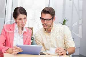 Business colleagues holding coffee cup and digital tablet