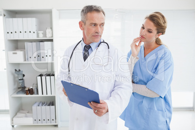 Serious doctor showing nurse a chart