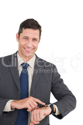 Businessman using his smart watch and smiling at camera
