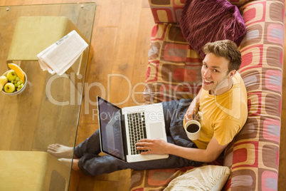 Young man using laptop on his couch