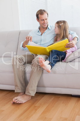 Casual father and daughter looking at photo album