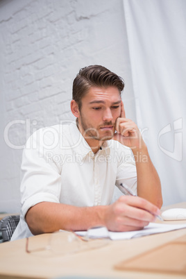 Businessman writing documents at office