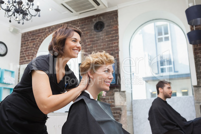 Smiling hairdresser chatting with customer