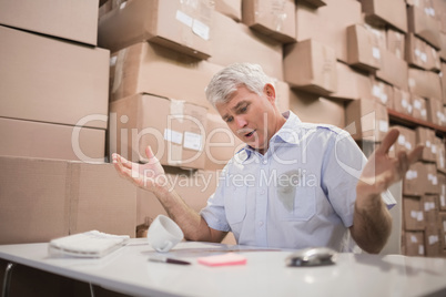 Worried warehouse manager at desk