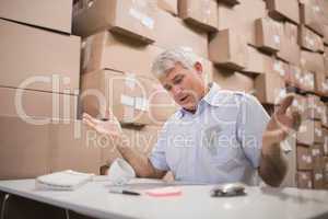 Worried warehouse manager at desk