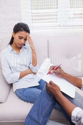 Woman sitting on therapists couch looking down