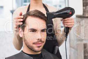 Hair stylist drying mans hair