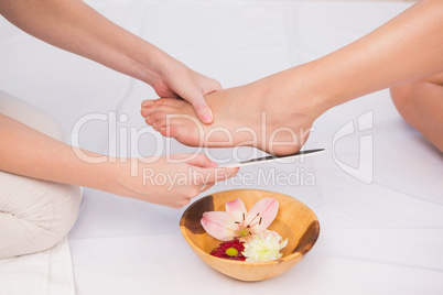 Woman getting a pedicure from beautician