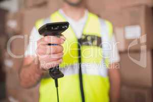 Mid section of worker holding scanner in warehouse