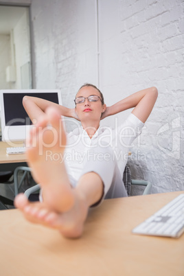 Businesswoman with legs crossed at ankle on desk