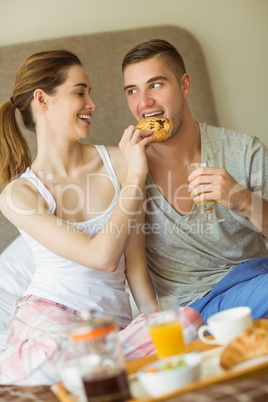 Cute couple having breakfast in bed