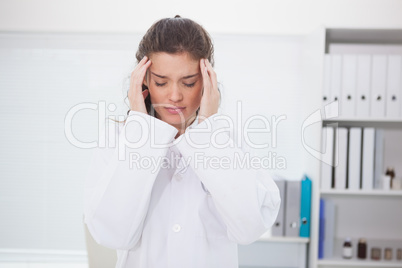 Brunette doctor suffering of headache