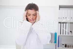 Brunette doctor suffering of headache