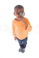 Cute boy looking through a magnifying glass