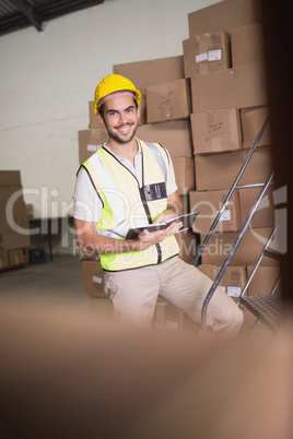 Worker with diary in warehouse