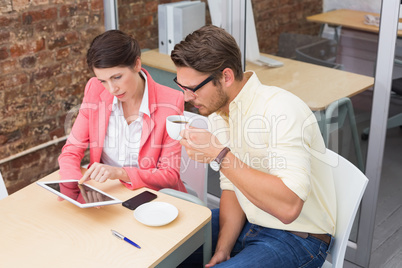 Business colleagues holding coffee cup and digital tablet