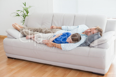 Father and son using napping on the couch