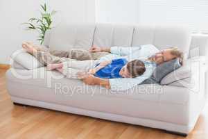 Father and son using napping on the couch