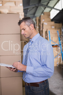 Manager holding clipboard in warehouse