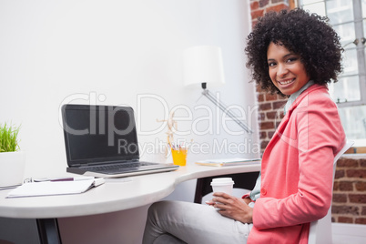 Pretty casual businesswoman sitting at desk