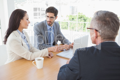 Co workers all looking at a laptop