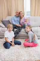 Happy parents with their children on sofa