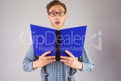Geeky businessman holding a book