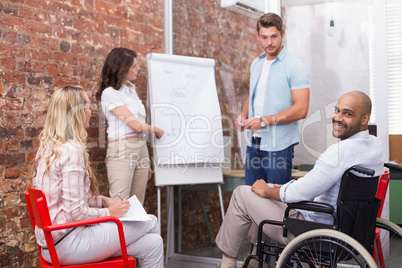 Man in wheelchair smiling at camera during presentation