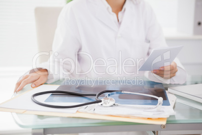 Doctor sitting at her desk with laptop and files