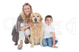 Smiling mother and son petting their golden retriever