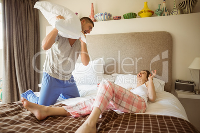 Cute couple having a pillow fight