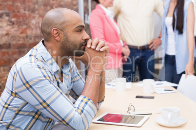 Focused man sitting at desk using his tablet