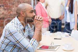 Focused man sitting at desk using his tablet