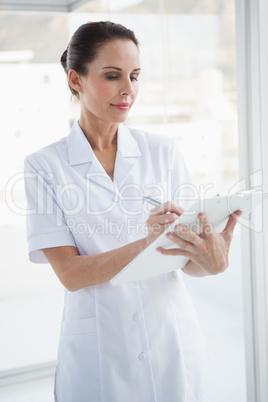 Doctor writing on her chart