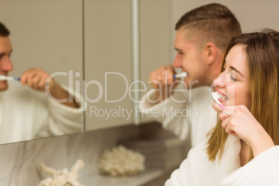 Cute couple brushing their teeth