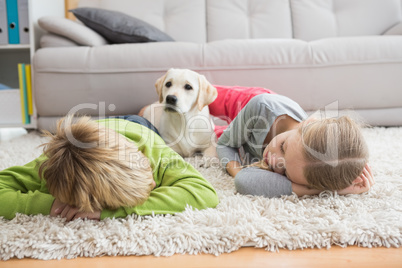 Cute silblings with their puppy on rug