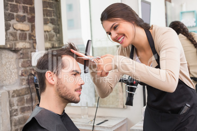 Handsome man getting his hair trimmed