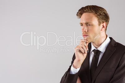 Young businessman thinking with hand on chin