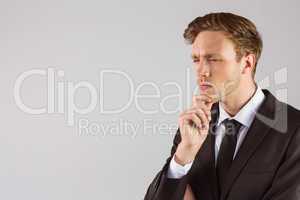 Young businessman thinking with hand on chin