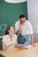 Casual colleagues using digital tablet and telephone