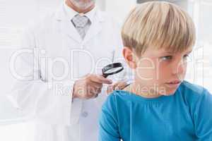 Doctor examining patient with magnifying glass