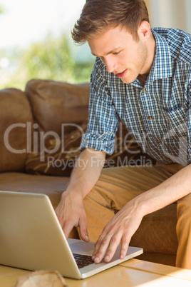 Young man using laptop on his couch