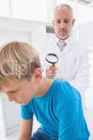 Doctor examining patient with magnifying glass