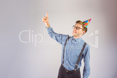 Geeky hipster wearing party hat pointing