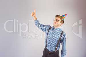 Geeky hipster wearing party hat pointing