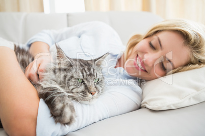 Happy blonde with pet cat on sofa