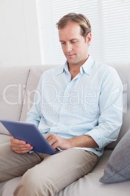 Casual man using tablet on the couch