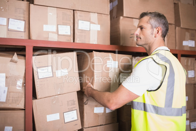 Worker loading up shelf in warehouse