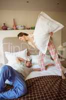 Cute couple having a pillow fight