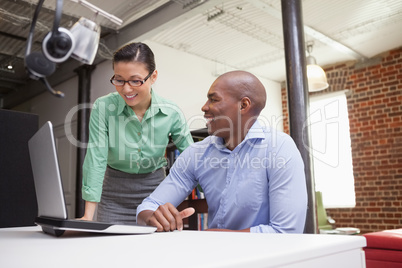 Casual business team working together with laptop